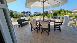 Un patio con mesa y sillas, un sofá y una sombrilla grande.