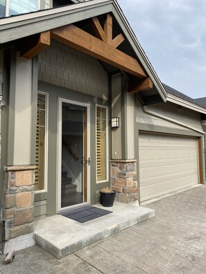 Stylish entrance with a glass door and wooden shutters, elevated from the ground level.
