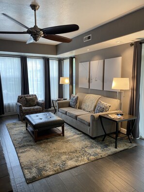 Relax in this stylish living room with a sofa set, coffee table, and floor lamps.