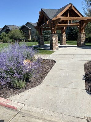 Stroll through the beautifully landscaped garden, surrounded by vibrant purple flowers and stone pillars.