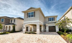 A modern two-story house with a central courtyard, stone accents, and a garage.