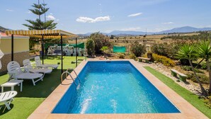 A swimming pool with a view of mountains, surrounded by a patio with chairs and a covered area. - Cubo's Finca Fernando / private pool / free wifi (Coín)