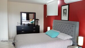 A bedroom with a bed, a dresser, a mirror, and a framed picture on the wall. - Casa 12-1 - Pet Friendly, Amazing view, and Newly Renovated (San Carlos)