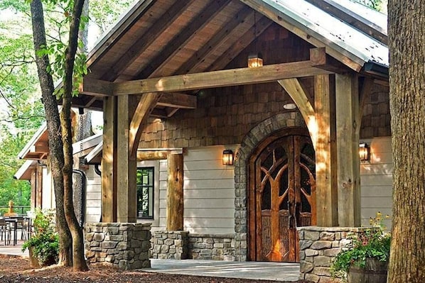 Una cabaña rústica con cimientos de piedra, vigas de madera y una gran entrada en arco.
