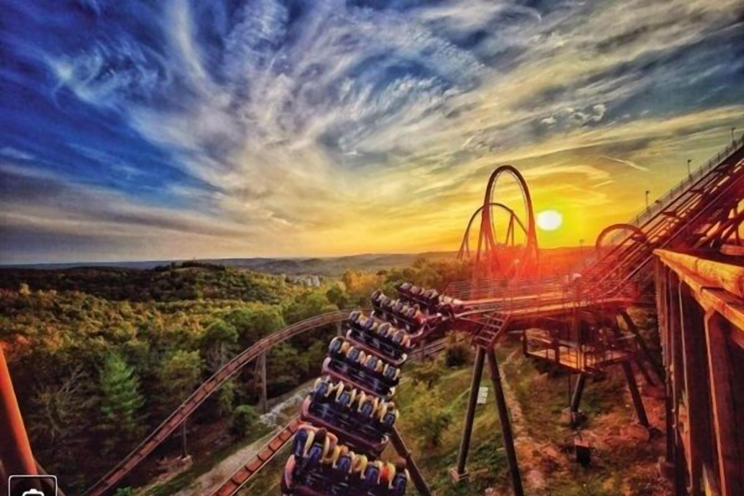 A roller coaster at sunset with a scenic view of the surrounding landscape.