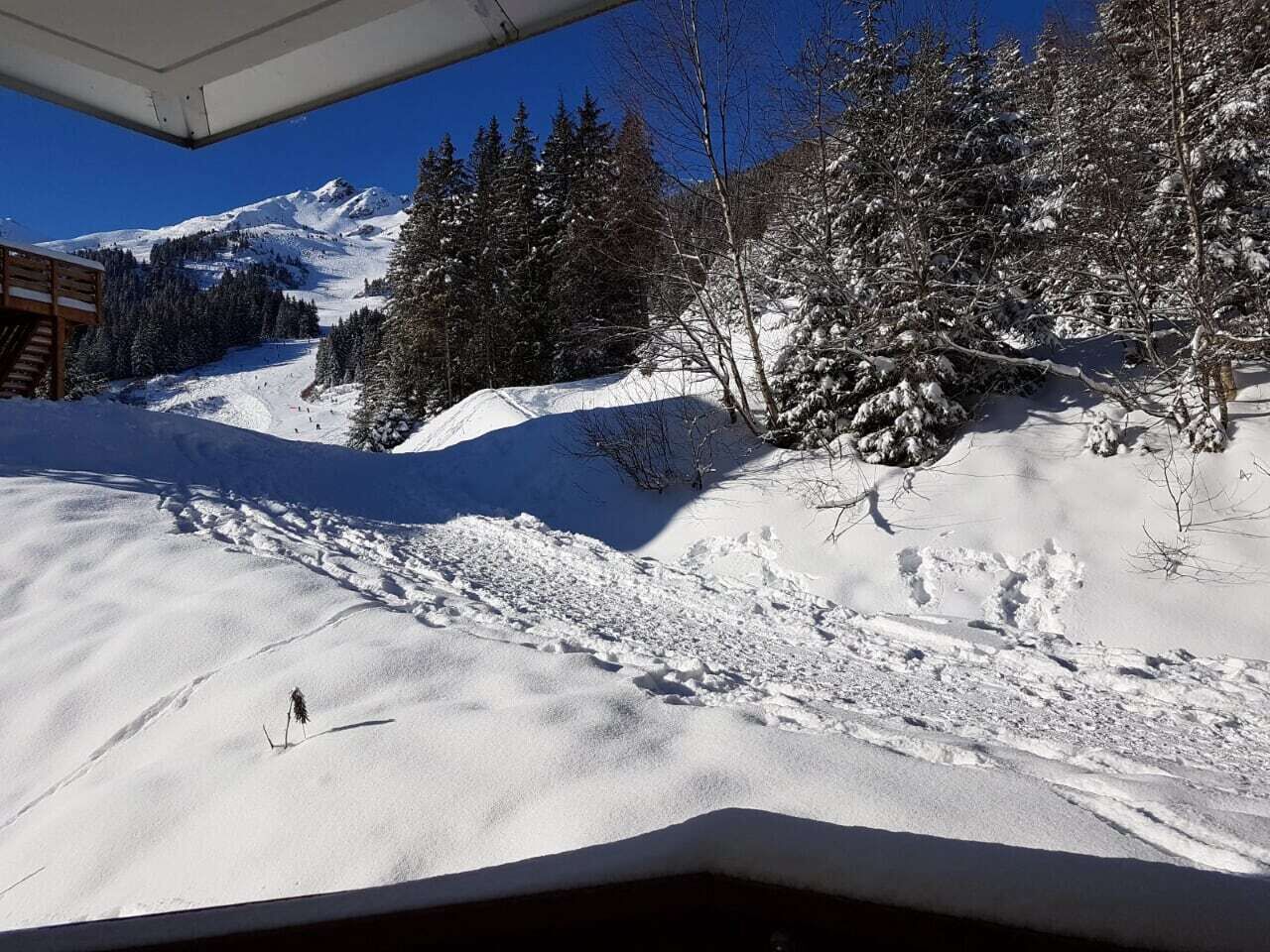 A snowy mountain landscape with a cabin and a ski slope.