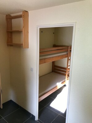 A room with a bunk bed and a wooden shelf unit. - Apartment at the Foot of the Slopes - STATION LE PLEYNET (Le Pleynet)