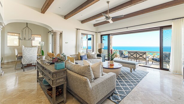 A spacious living room with a large sofa, a coffee table, and a view of the ocean through a sliding glass door. - 3 BD Oceanview Penthouse with infinity pool and jacuzzi (San Jose del Cabo)