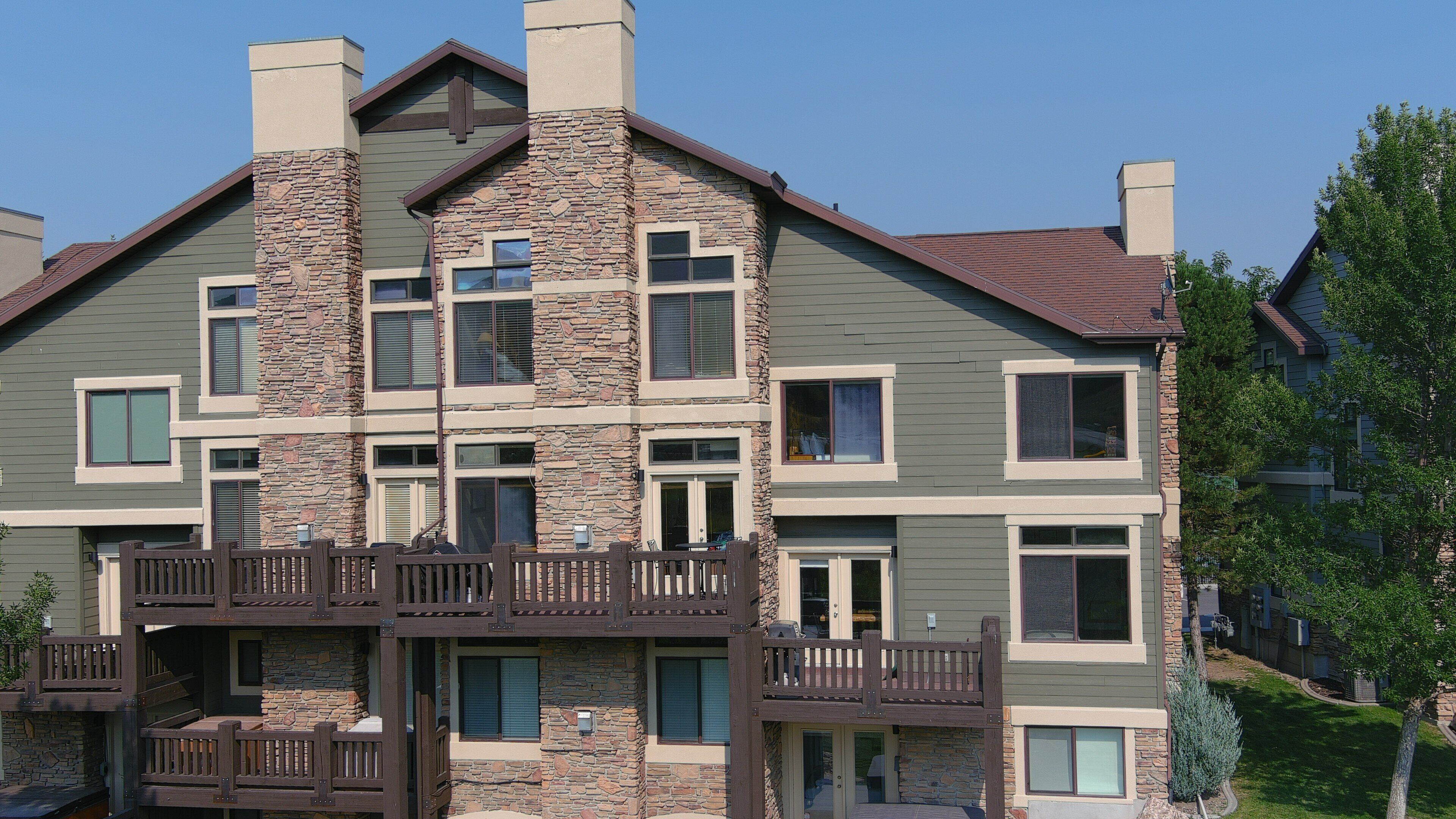 A multi-story building with a stone facade, multiple balconies, and a flat roof.