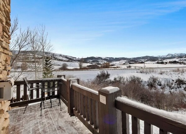 A balcony with a view of a snowy landscape and distant mountains.