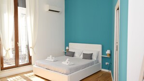 Un dormitorio moderno con cama, cortinas y vistas por la ventana.