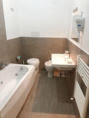 Un baño con bañera, inodoro y lavabo.