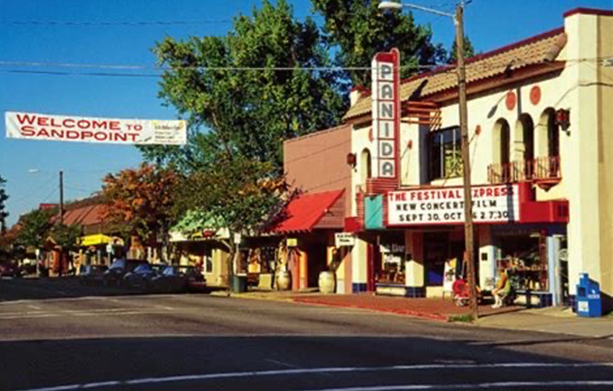 A street view with a building labeled 'Sandpoint' and a sign for 'The Festival Express' with a date and time.