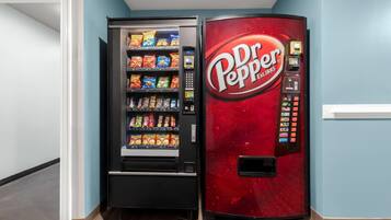 Máquina expendedora con el logotipo de Dr. Pepper y otra máquina expendedora de snacks a su lado.