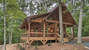 A wooden cabin with a deck, surrounded by trees. - Peaceful Cabin on 3 Private Acres: Deck & Fire Pit (Blairsville)