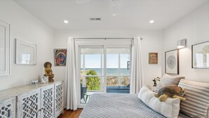 Ein Schlafzimmer mit Bett, Meerblick, einem Balkon und einem dekorativen Schrank.
