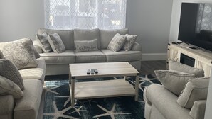 Ein Wohnzimmer mit einer Couch, einem Couchtisch und einer TV-Konsole.