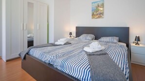 Un dormitorio con una cama grande, un armario y un cuadro en la pared.