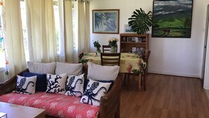 Una sala acogedora con sofá, mesa de comedor y estantería.