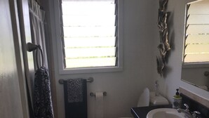 Un baño con inodoro, lavamanos y ventana.
