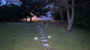 A nighttime outdoor pathway with stepping stones and lights. - The best OBX sunsets (Waves)