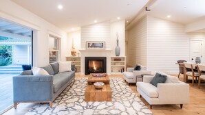 Un salón amplio con chimenea, sofás y un comedor.