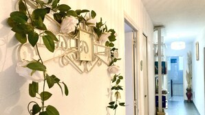 Un corridoio con un cartello metallico decorativo fissato al muro, raffigurante rose e foglie.