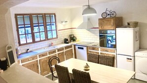 Una cucina compatta con zona pranzo, mobili in legno, forno a incasso e una decorazione a tema bicicletta al muro.