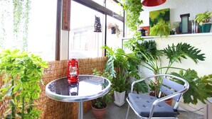 A small balcony with a table, chairs, hanging plants, and a potted plant. - Jonni’s Place (Otsu)