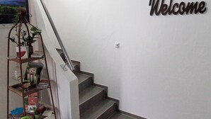 Una escalera con barandilla de metal y un cartel de bienvenida en la pared.