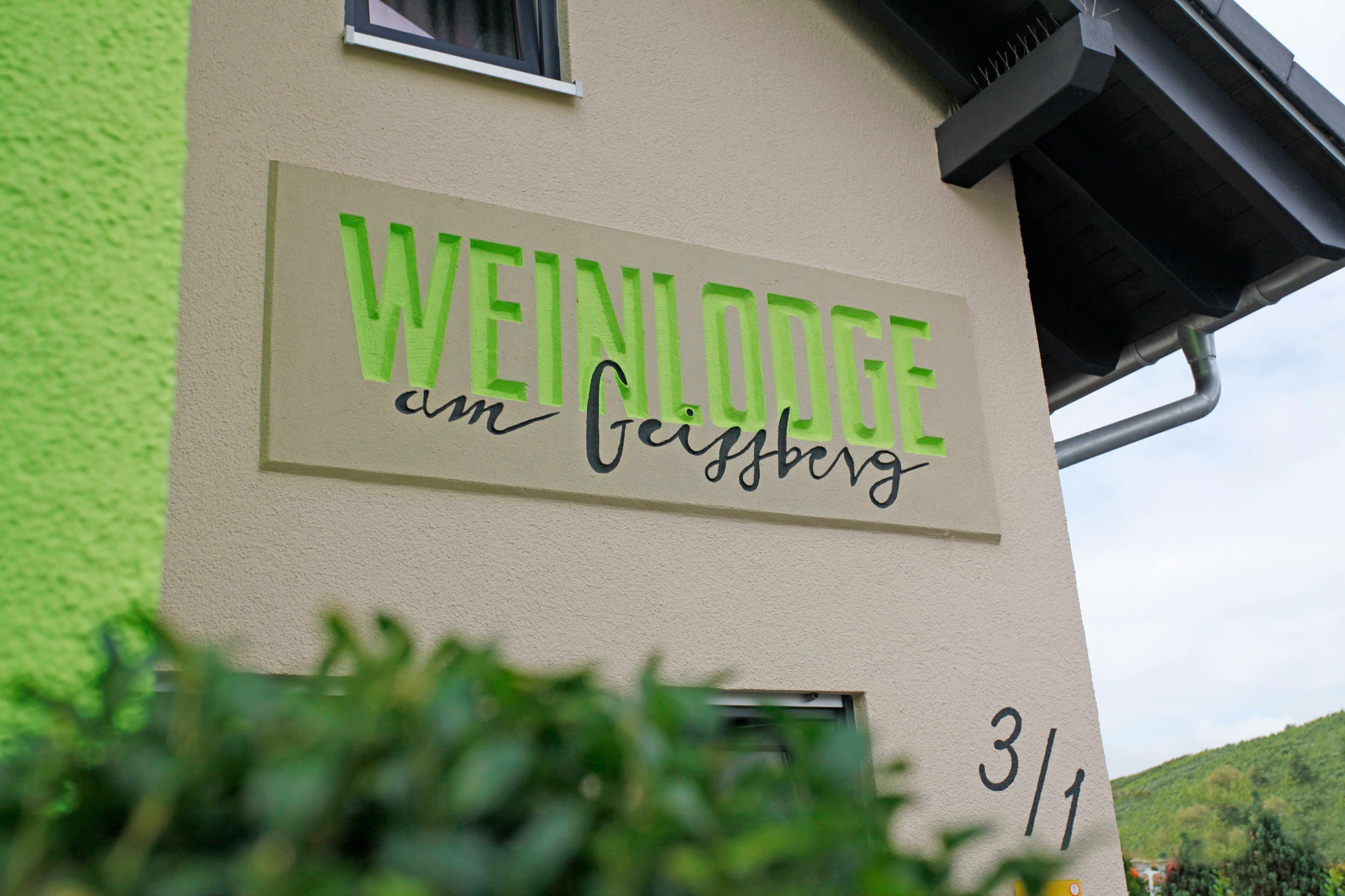 Un bâtiment portant une enseigne indiquant « WEINLODGE am Geisberg » et l’adresse « 3/1 ».