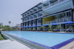Una piscina al aire libre, camas de piscina gratis, sombrillas