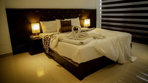 A hotel room with a large bed, two bedside lamps, and a heart-shaped towel arrangement. - Trincomalee Beach Resort & spa (Trincomalee)