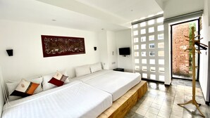 Une chambre moderne avec un grand lit, une plateforme en bois, un téléviseur et un élément décoratif mural.