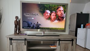 A flat-screen TV on a wooden entertainment center with a remote control and a book. -  Updated  farm style Apt.  w/ loft minutes from Airport and Seattle (Tukwila)