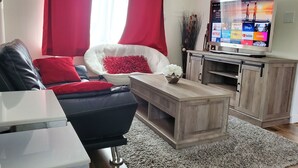 A living room with a sofa, a coffee table, a TV, and a cabinet. -  Updated  farm style Apt.  w/ loft minutes from Airport and Seattle (Tukwila)