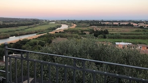 A river winding through a rural landscape with fields and a few buildings in the distance. - Modern apartment in the historic center of Orosei 70 M² - French Alps  (OROSEI)
