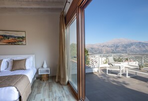 A bedroom with a large bed, a nightstand, a bedside table, and a window with a view of mountains. - Luxury privacy in Cretan countyside (Meronas)