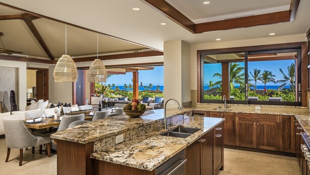 A modern kitchen with a large island, granite countertops, and a view of the ocean. - Luxury 5BR Kulanakauhale Estate 3558 at Hualalai – Infinity Pool & Ocean Views (Kailua Kona)