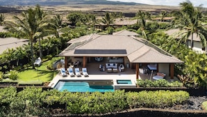 A resort with a swimming pool, outdoor seating, and a view of the surrounding landscape. - Luxury 5BR Kulanakauhale Estate 3558 at Hualalai – Infinity Pool & Ocean Views (Kailua Kona)