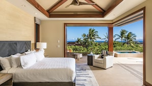 A bedroom with a large bed, a ceiling fan, and a view of a pool and palm trees. - Luxury 5BR Kulanakauhale Estate 3558 at Hualalai – Infinity Pool & Ocean Views (Kailua Kona)