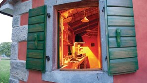 A rustic kitchen with wooden shutters, a hanging light fixture, and a visible countertop. - Breathtaking villa with a private pool (Labin)