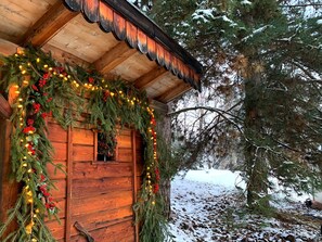 Eine rustikale Holzhütte, umgeben von schneebedecktem Boden und Bäumen.