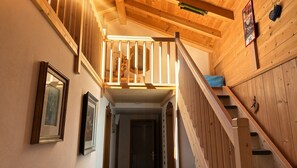 A wooden interior with a staircase leading to a loft area.