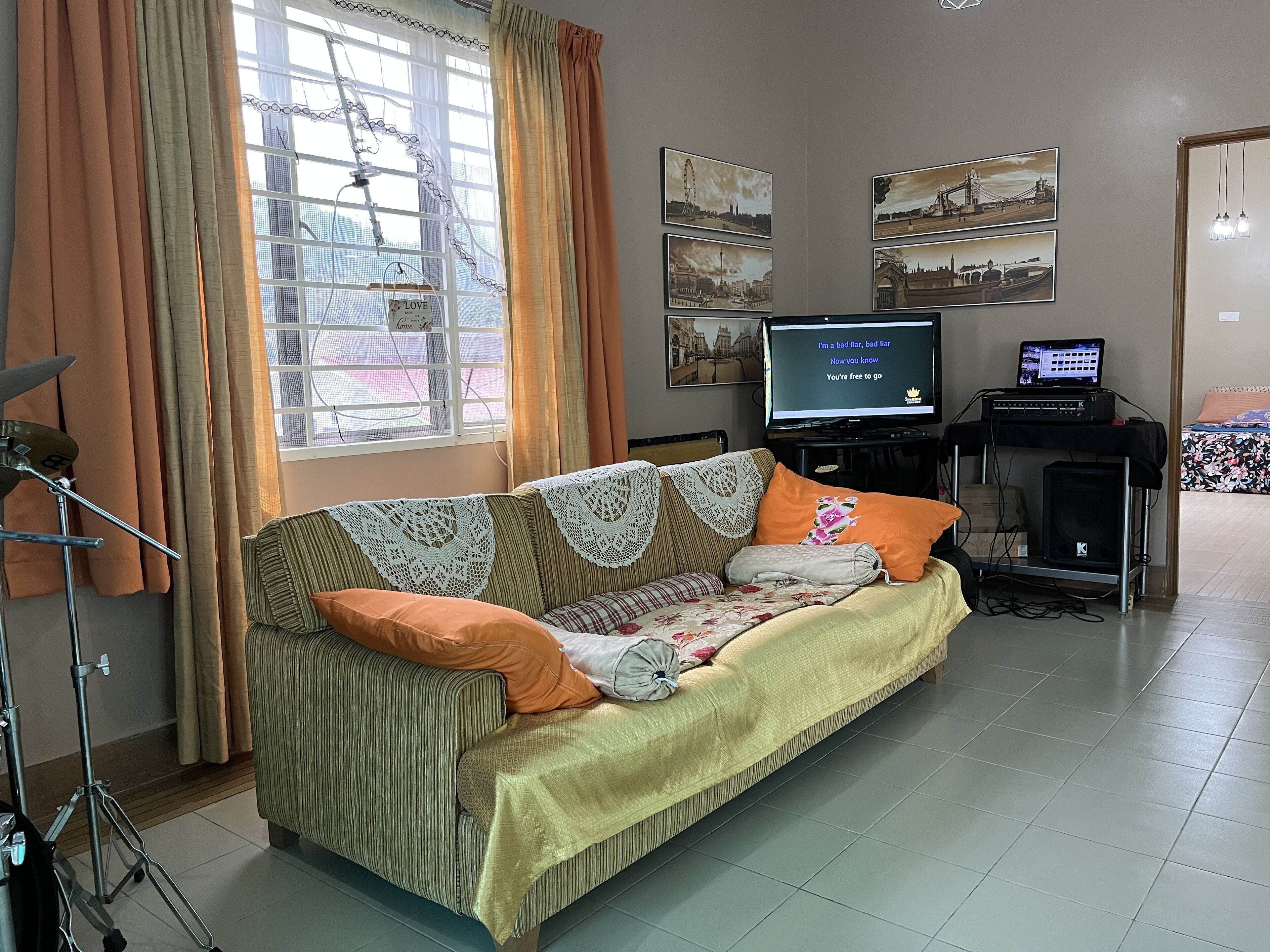 A living room with a sofa, a television, and a sound system.