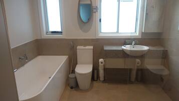 Bathtub, towels, soap, toilet paper