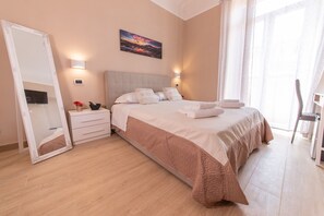 Une chambre à coucher avec un grand lit, une table de chevet, un miroir et un tableau accroché au mur.