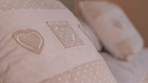 A pillow with heart-shaped and rectangular embroidered designs. - Le Camere di Teo 2 (La Spezia)