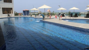 Outdoor pool, pool umbrellas, lifeguards on site
