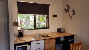 A compact kitchen with a window, sink, and a toaster.